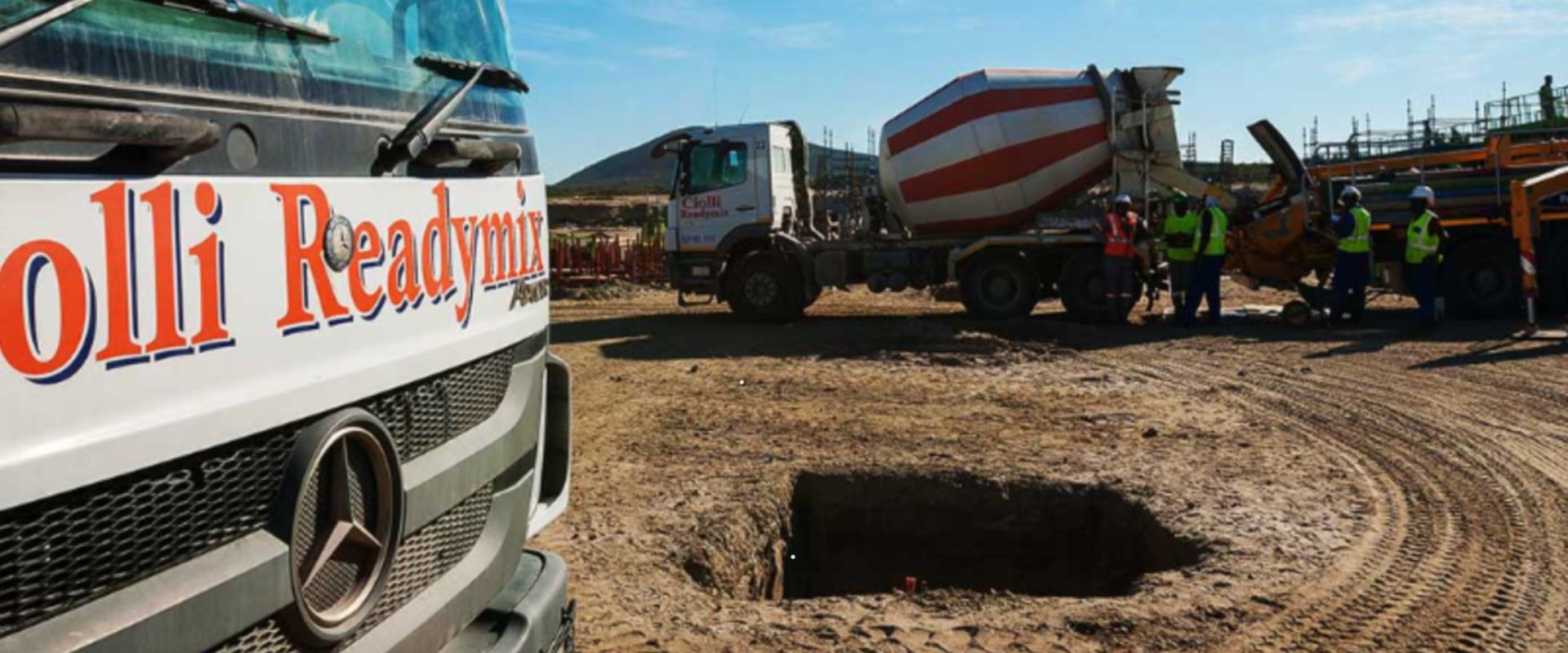 Readymix concrete truck with workers at sunset